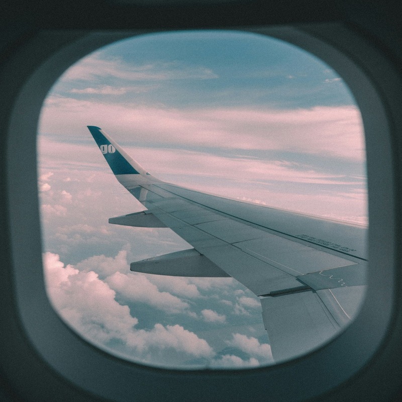 Business traveler working on laptop at airport lounge with SOTO travel ticket, representing cost-saving corporate travel management solutions